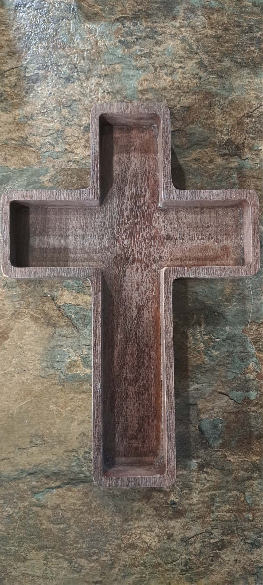 A rustic dark brown wooden cross with a carved, textured finish, that can be displayed on a table, laying down or standing up or it can be hung up on the wall with the provided mounting.
  can also be used to hold small items like jewelry, watches or keys or just be displayed all on its own.